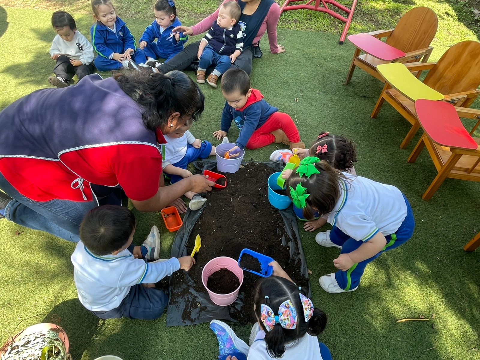 Niñas y niños trabajando en el huerto escolar de Reggio Emilia Xalapa